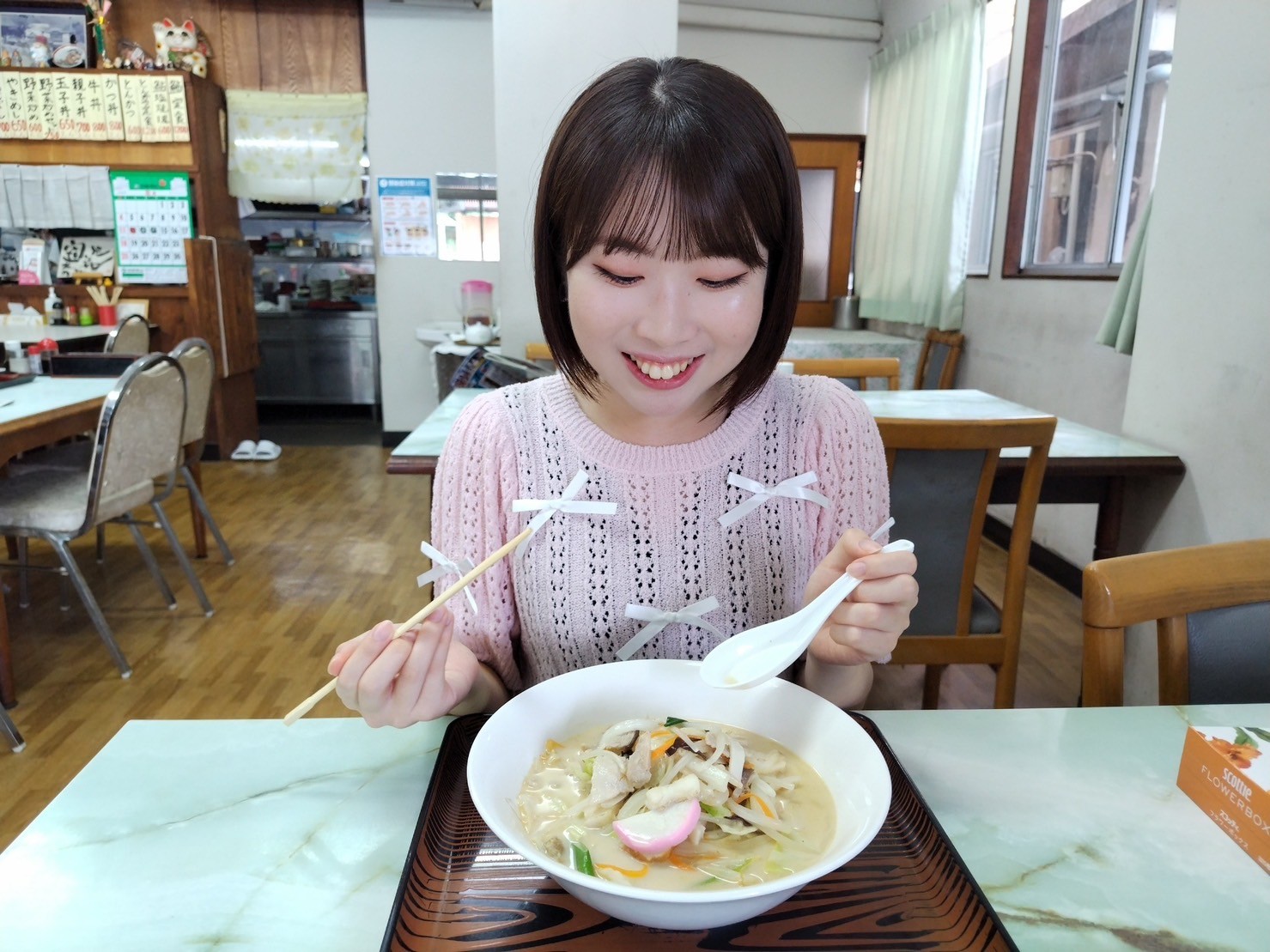 テーブルで食事をしている女性自動的に生成された説明