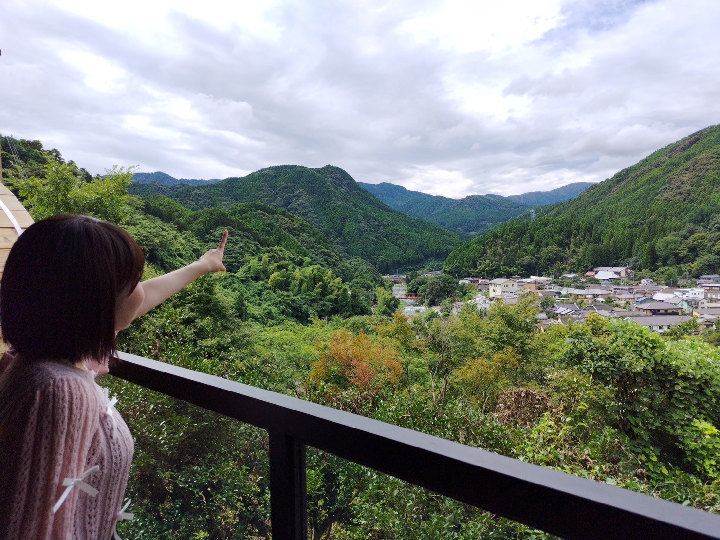 山の中の橋の上を歩いている女性低い精度で自動的に生成された説明